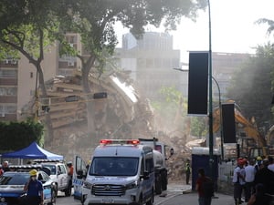 Equipos de búsqueda y rescate trabajan entre los escombros de un edificio derrumbado.
