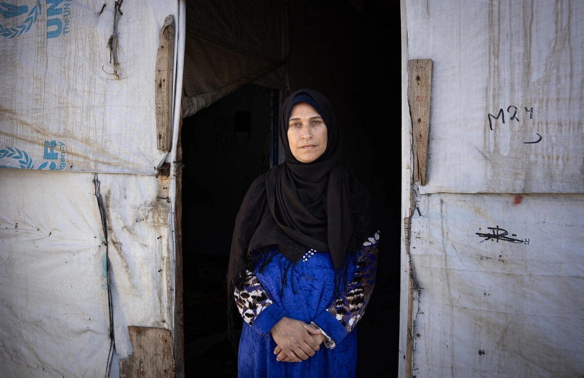 Shadia Mohammad Jesm, 50, está na entrada de sua tenda no assentamento de refugiados Jasmine em Saadnayel, Líbano