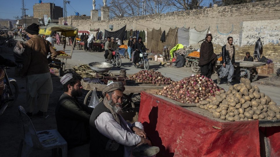 Pessoas passam por uma movimentada área comercial em Ghousabad, um bairro de Quetta, onde 60% dos residentes são refugiados afegãos