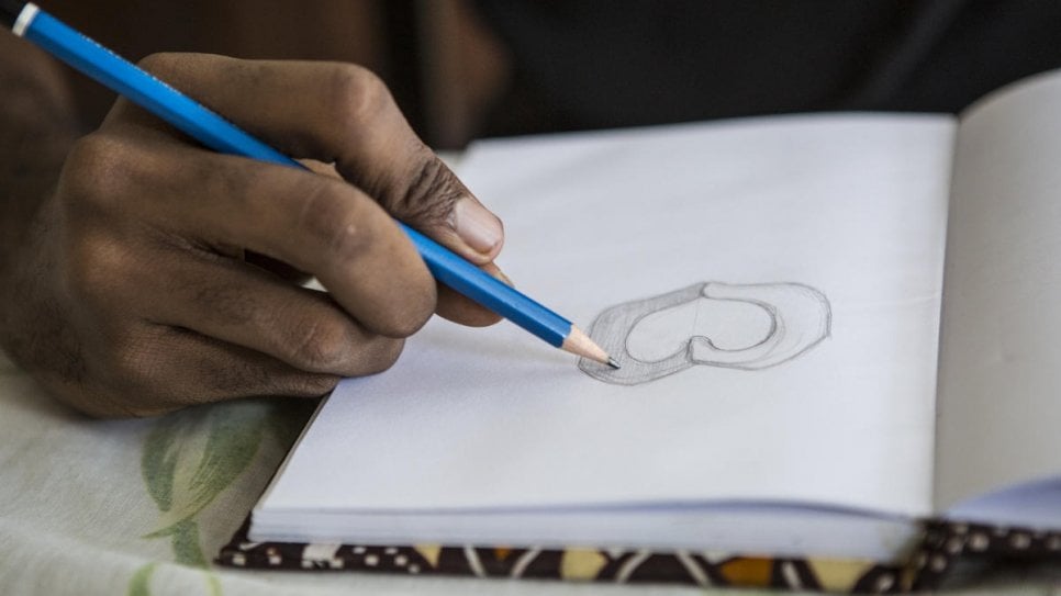 O designer gráfico da Costa do Marfim O'Plérou desenvolve seus emojis como esboços em papel antes de projetá-los no computador