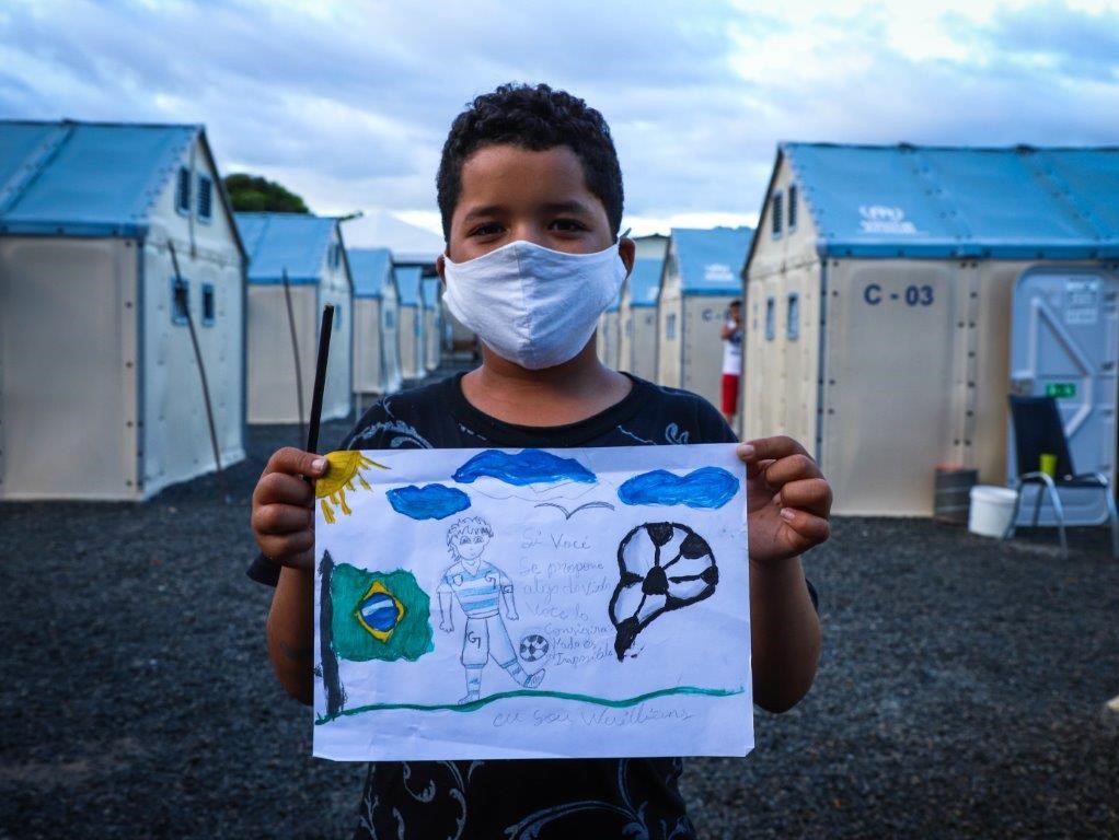 Williams com seu desenho sobre o que ele deseja para seu futuro no Brasil