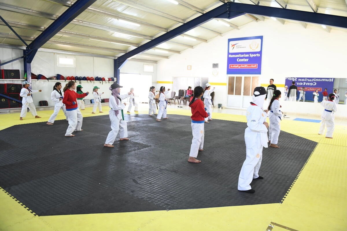 Um grupo de meninas refugiadas participa de uma sessão de treinamento no Centro Humanitário de Taekwondo no campo de refugiados de Azraq, na Jordânia, em abril de 2023. © Mohammad Alyounes/ACNUR