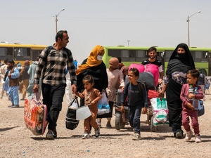 Família afegã retorna do Irã após atravessar a fronteira de Islam Qala, na província de Herat, no Afeganistão, em julho de 2025