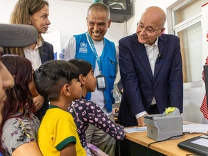 O Alto Comissário da ONU para Refugiados, Barham Salih, e colegas conversam com uma família venezuelana em um centro de proteção em Lima, Peru