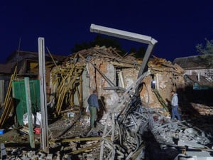 Pessoas avaliam os danos em prédios residenciais em Kharkiv após ataques aéreos em 2 de outubro de 2026