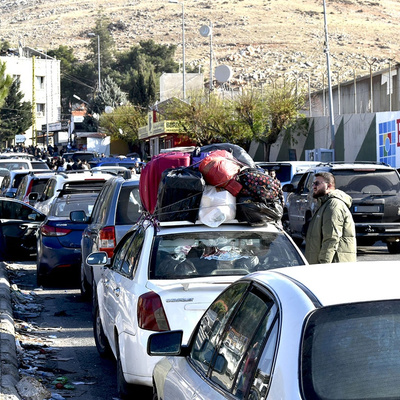 Filas de veículos se formam no ponto de fronteira de Masnaa, no Líbano, em 8 de dezembro, enquanto refugiados sírios aguardam para cruzar de volta para a Síria.