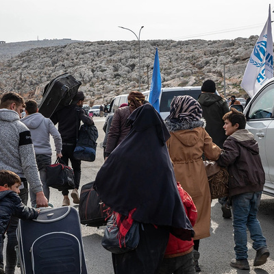 Uma família de refugiados sírios retorna ao norte da Síria vindo da Turquia, através da passagem fronteiriça de Bab al-Hawa.