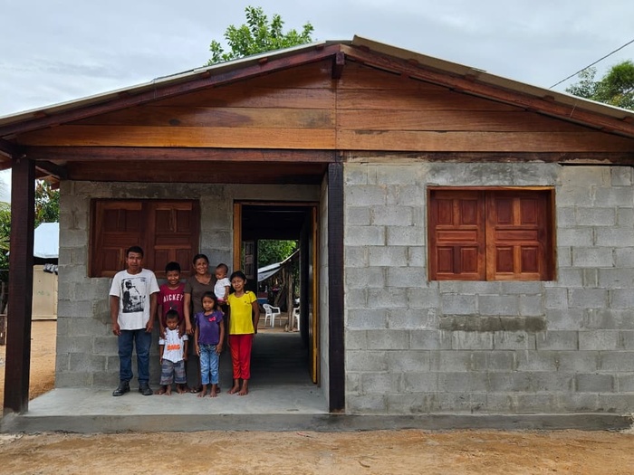 Casa construída com família na frente