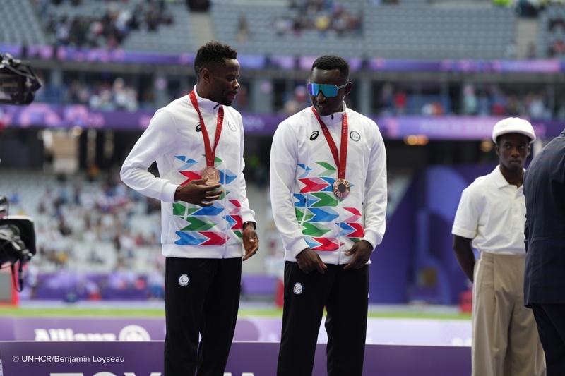 Guillaume Junior Atangana e seu guia Donard Nyamjua no pódio paralímpico, após receberem a medalha de bronze.