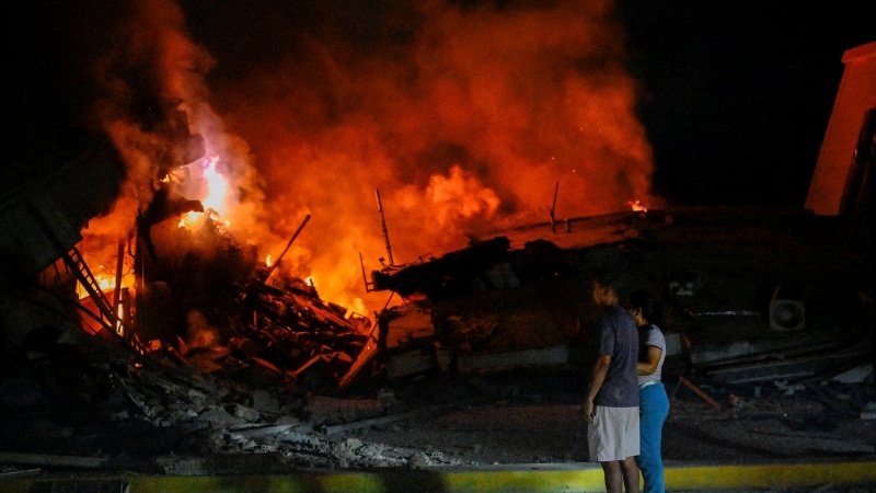 Pessoas em frente a prédios destruídos após terremoto em La Guaira, Venezuela