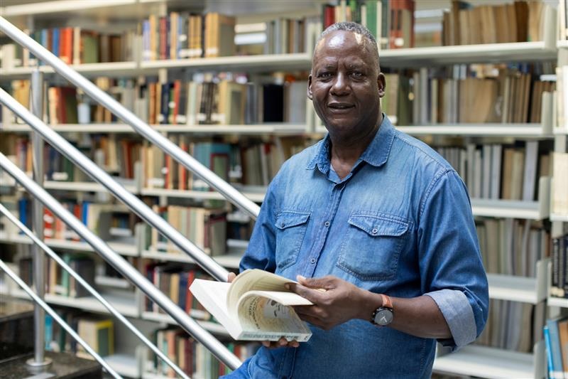 O professor mo&ccedil;ambicano Carlos Mabutana na biblioteca da USP