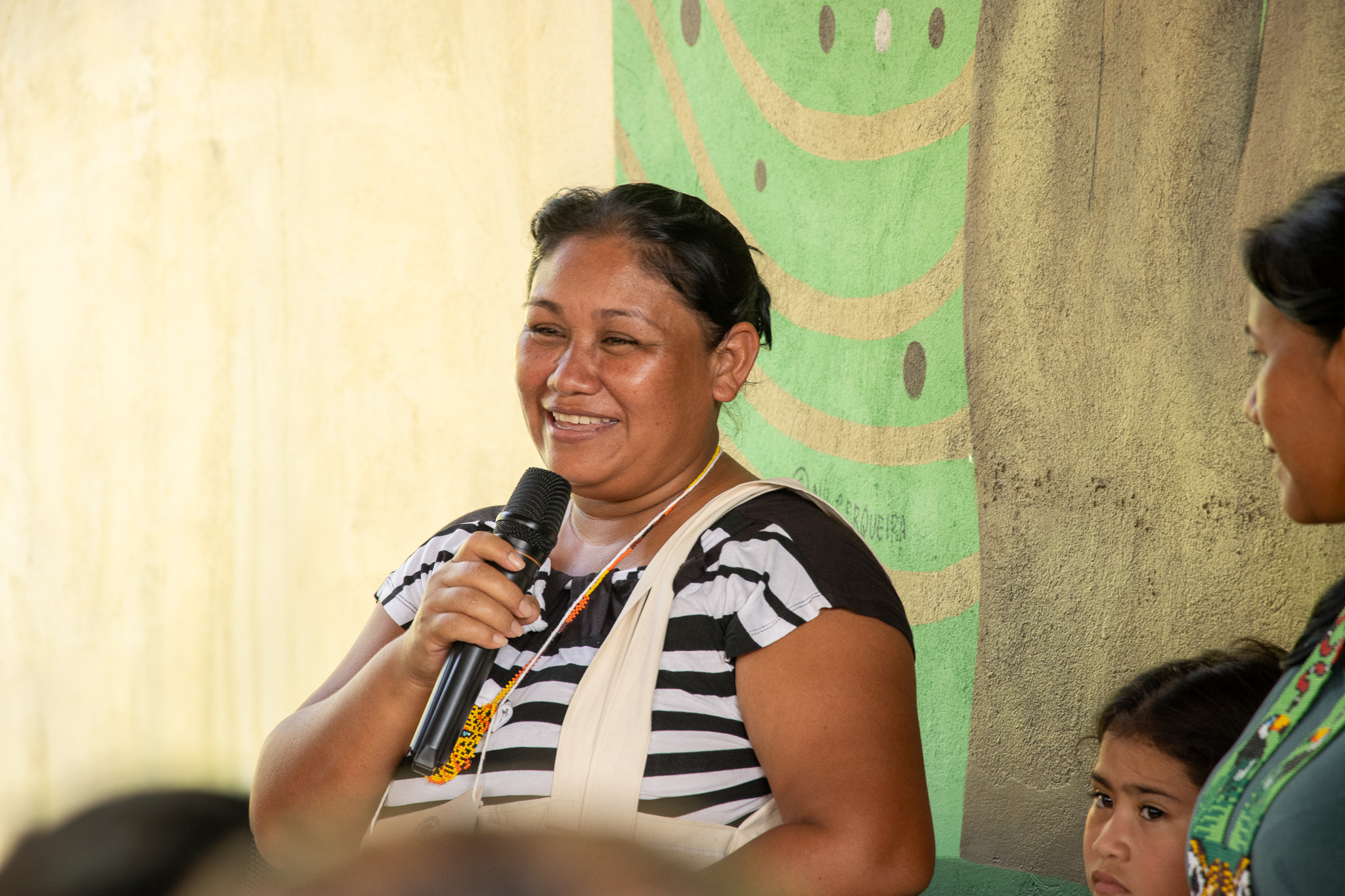 Mulher ind&iacute;gena da etnia Warao fala ao microfone sorrindo
