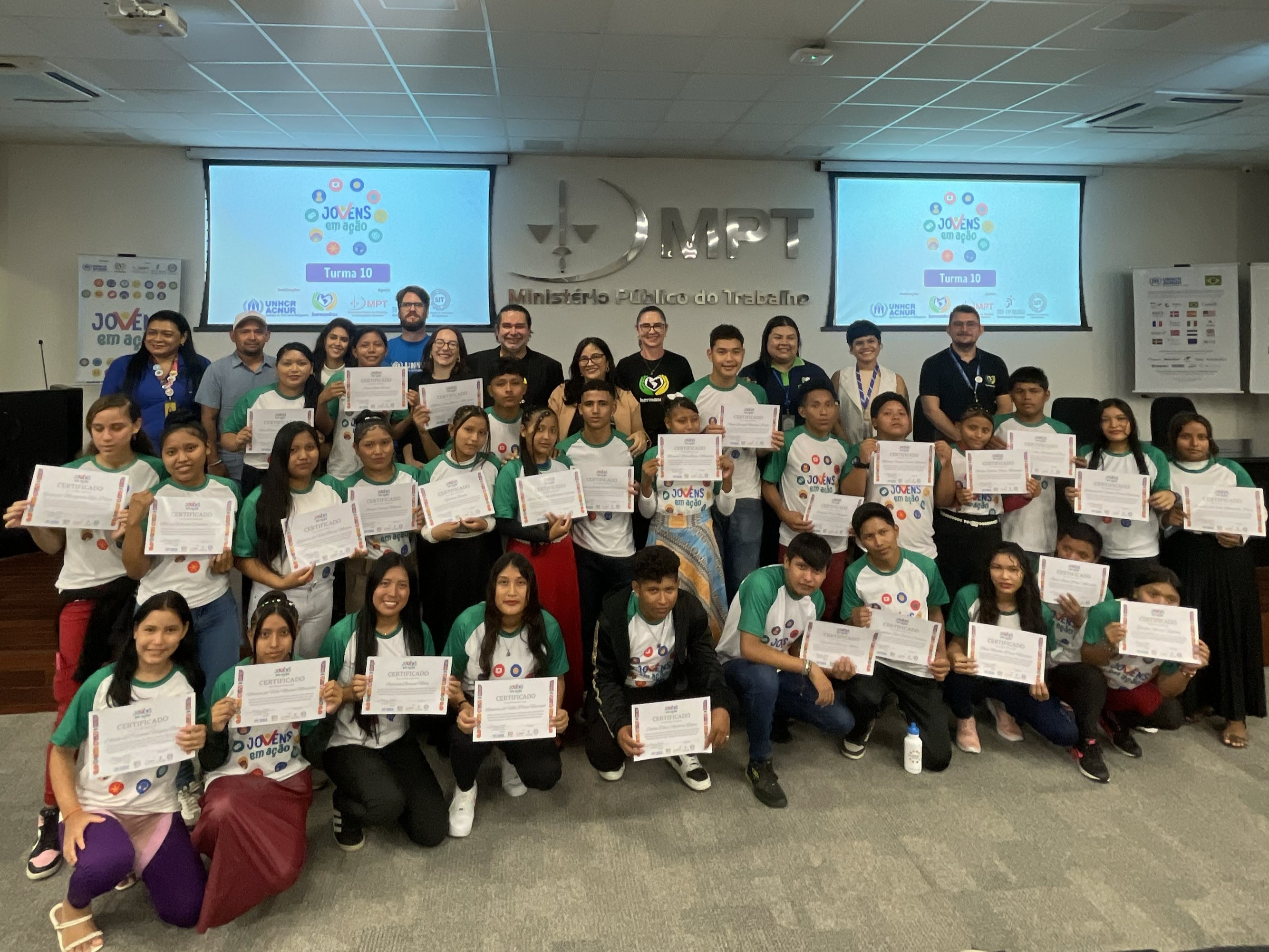 Grupo de pessoas jovens seguram diplomas em cerim&ocirc;nia de formatura 