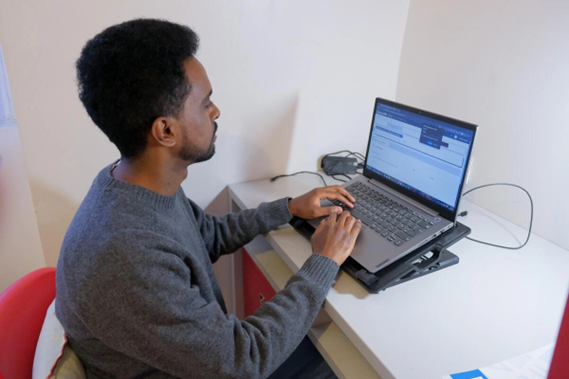 Faniel trabalha em seu laptop em sua resid&ecirc;ncia estudantil em Paris.
