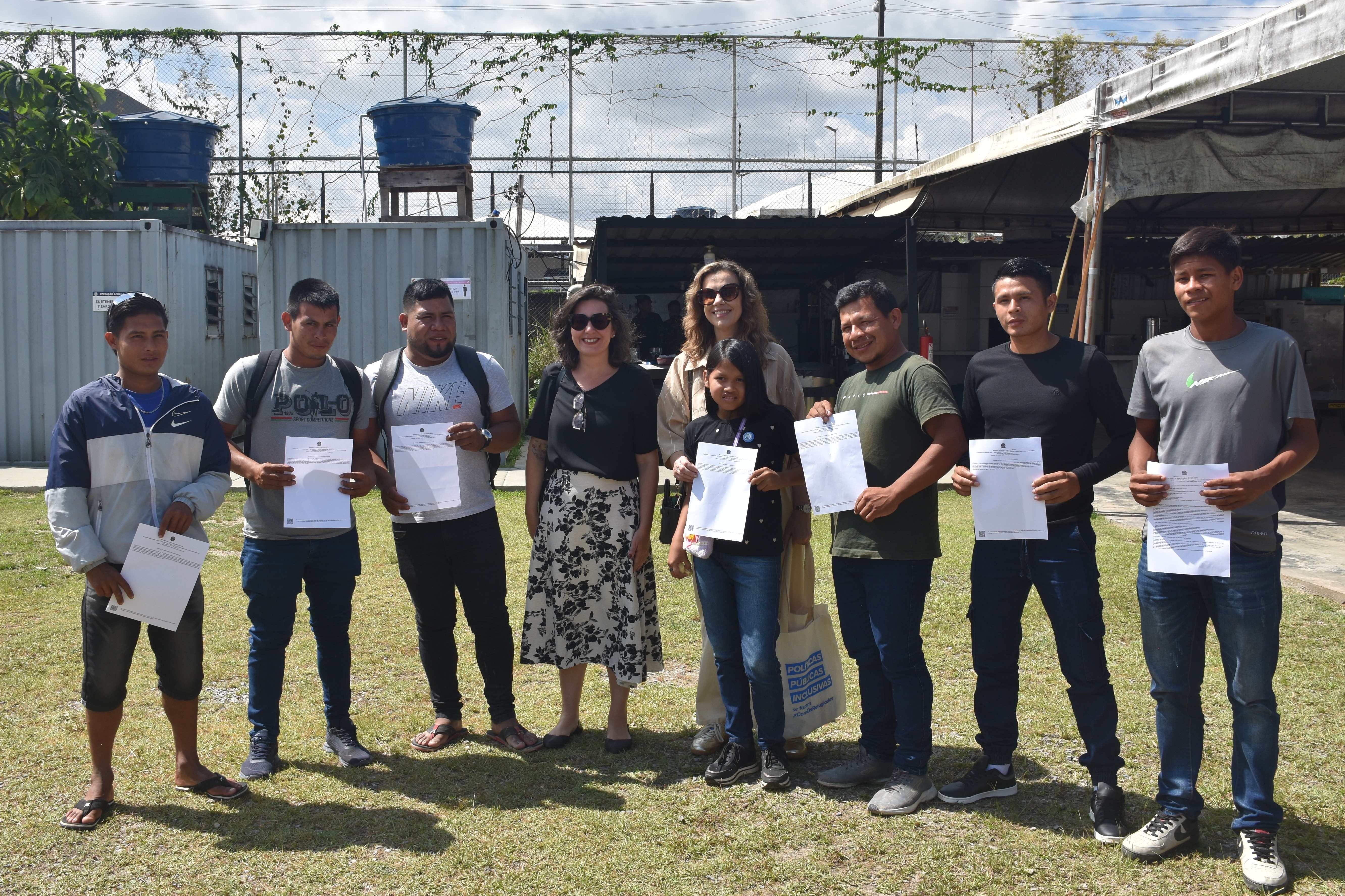 Integrantes de comunidades ind&iacute;genas Taurepang exibem certificados de reconhecimento da condi&ccedil;&atilde;o de refugiado ao lado de representantes do Governo Federal e do ACNUR em Pacaraima, Roraima.