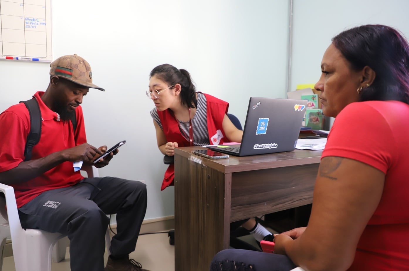 Atendimentos contaram com apoio e orienta&ccedil;&otilde;es de equipes da CASP; na foto, o haitiano Jean e a venezuelana Petra recebem instru&ccedil;&otilde;es sobre documenta&ccedil;&atilde;o
