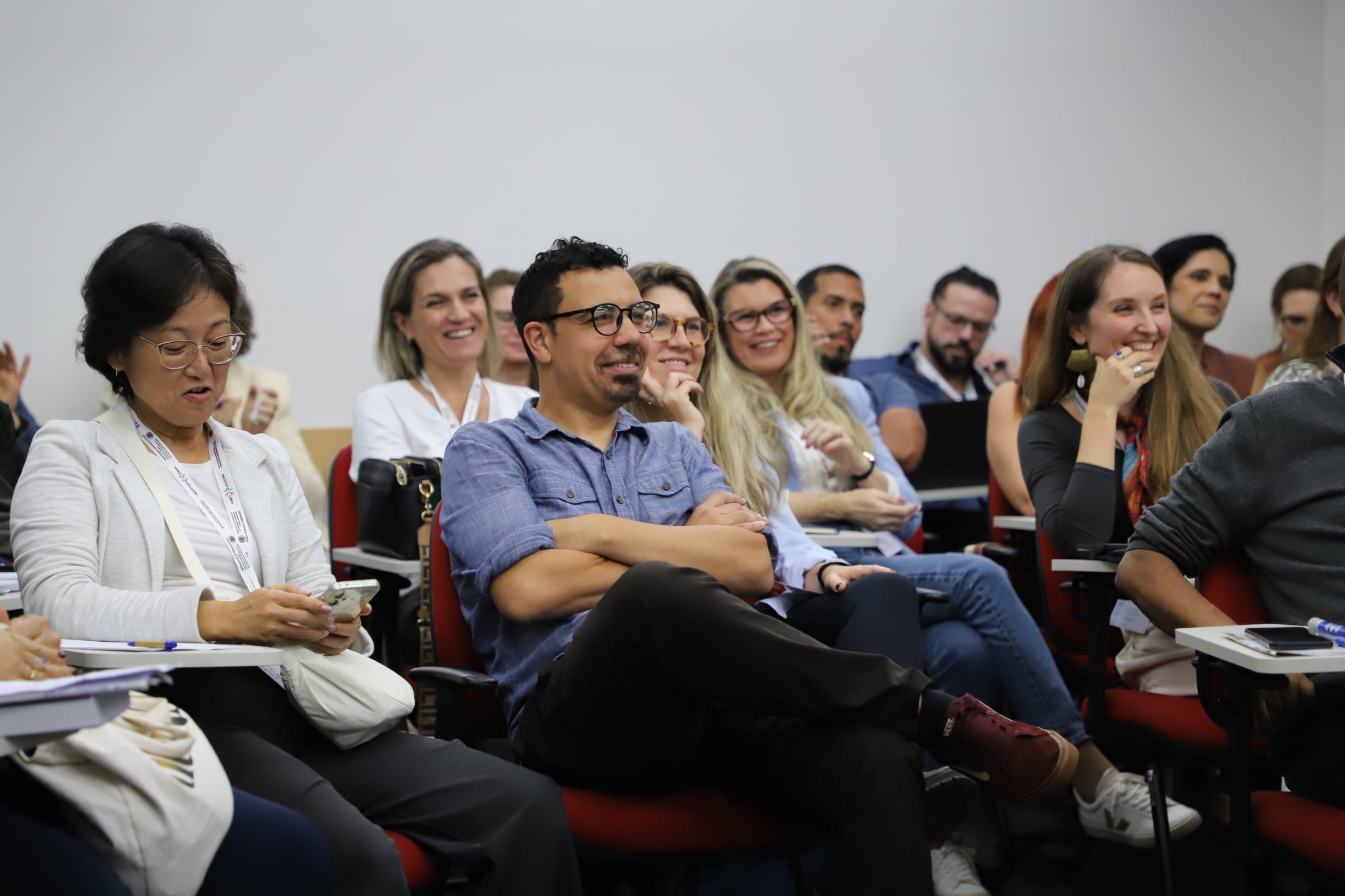 Pessoas sentadas em um audit&oacute;rio sorriem enquanto assistem apresenta&ccedil;&atilde;o do Semin&aacute;rio da C&aacute;tedra S&eacute;rgio Vieira de Mello