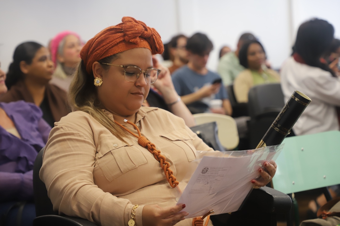 Yedimar olha para o diploma de Pedagogia revalidado pela UFPR