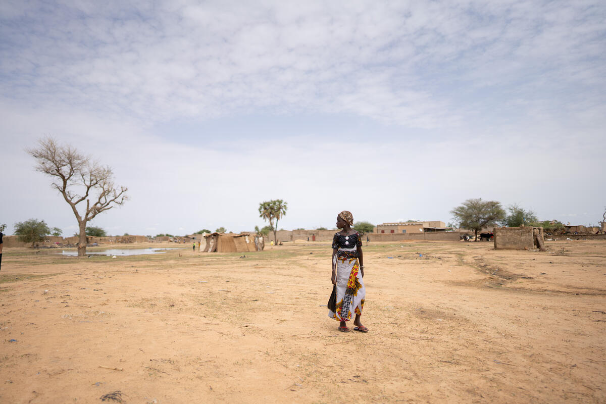 Uma mulher passa por uma grande poça criada pela chuva em Dori, Burkina Faso. Foto: ACNUR/Nana Kofi Acquah