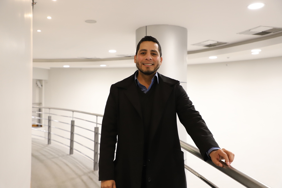 Franco Marval em corredor branco com traje formal 
