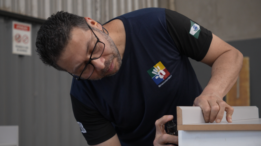 Montagem de móveis em fábrica no Brasil, profissional realizando acabamento e instalação com ferramentas