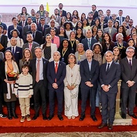 Grupo de personas en gradas y frontal a la cámara. 