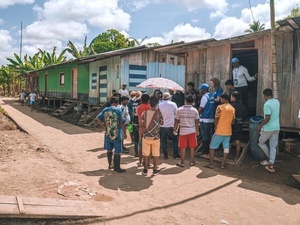 Personas y personal de ACNUR en una entrega de asistencia humanitaria 