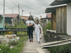 Una mujer joven y una niña afrocolombianas acera de madera