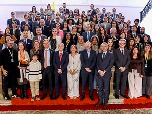 Grupo de personas en gradas y frontal a la cámara. 