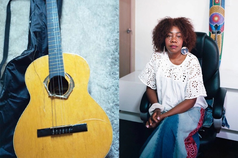 Guitarra y una mujer afrocolombian sentada 