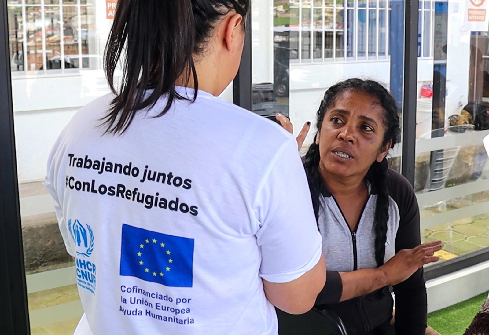 Mujer recibe atención de funcionaria de brigada móvil de registro y protección. 