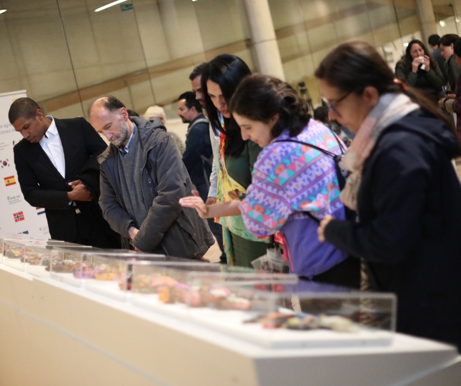 Asistentes hombre y mujeres a la exposición Refugiados y Migrantes en América