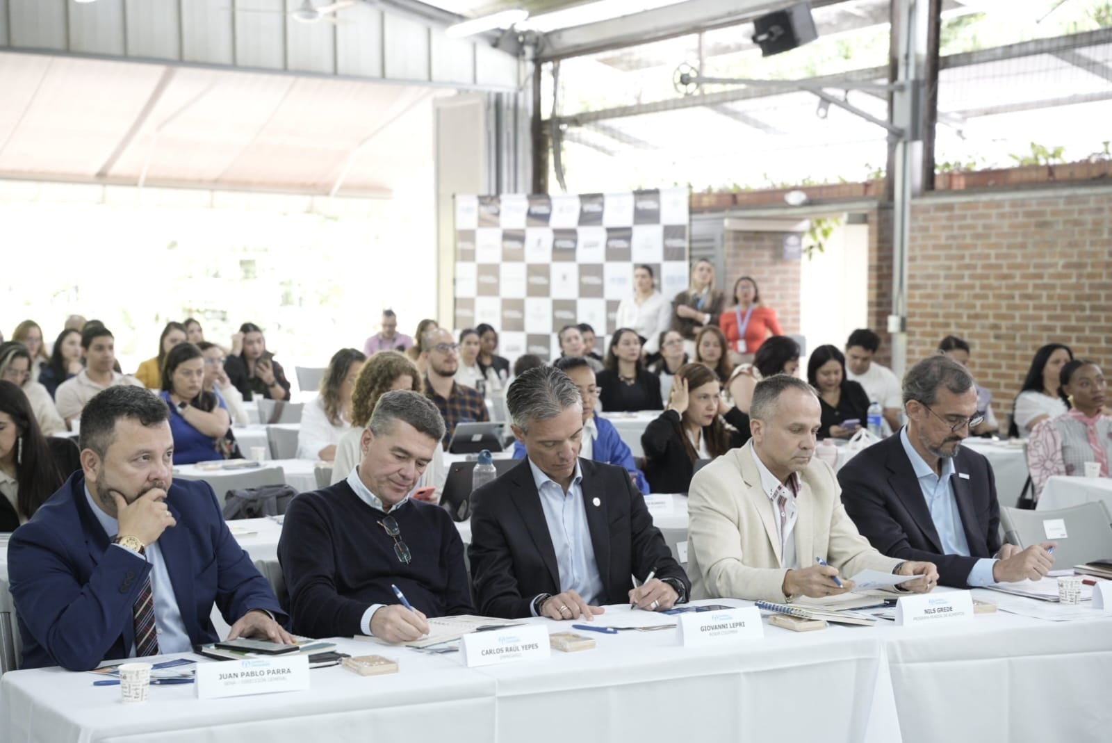 Hombres sentados en la mesa del foro de Juntos por la Inclusión