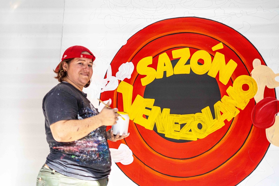 Mujer pinta logo tipo Sazón Venezolano 