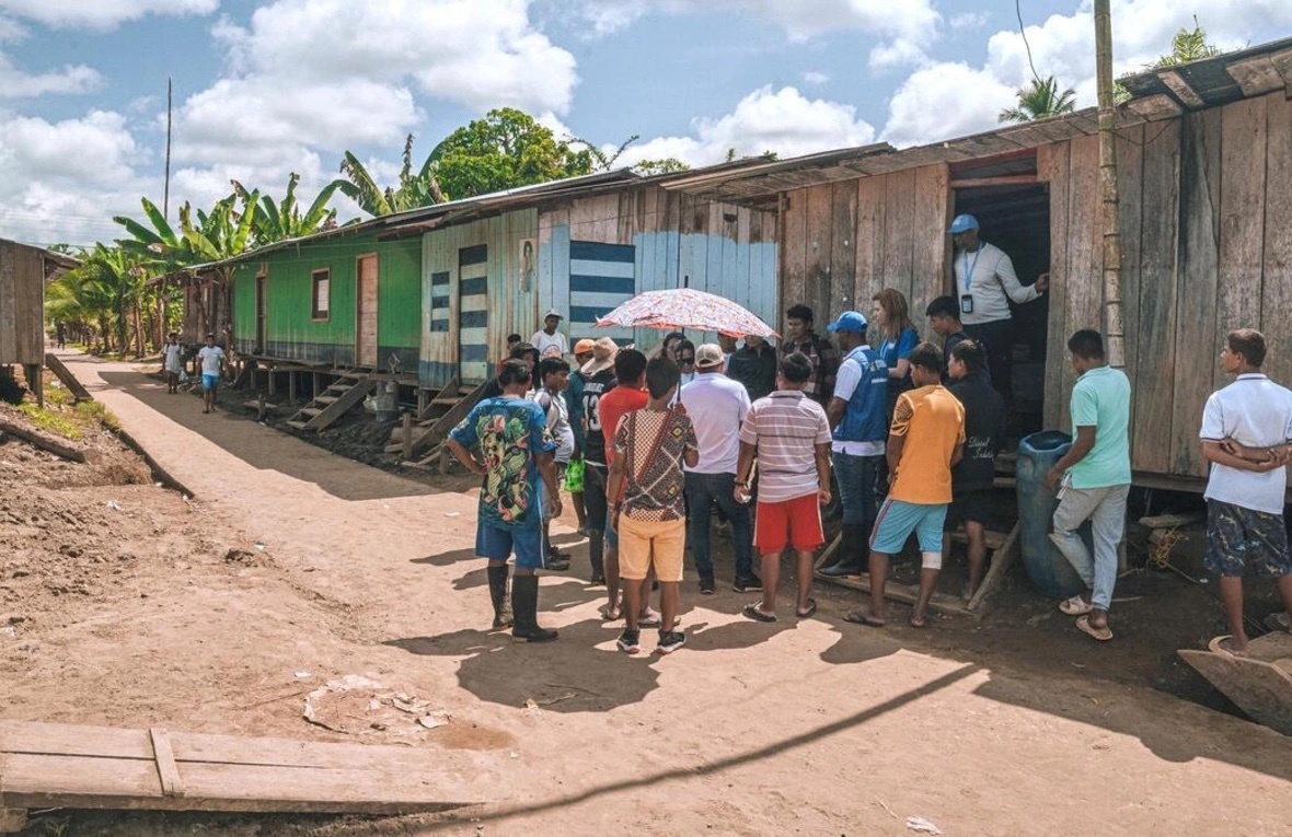 Personas y personal de ACNUR en una entrega de asistencia humanitaria 