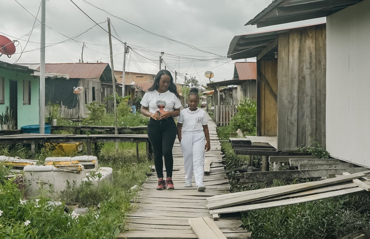 Una mujer joven y una niña afrocolombianas acera de madera