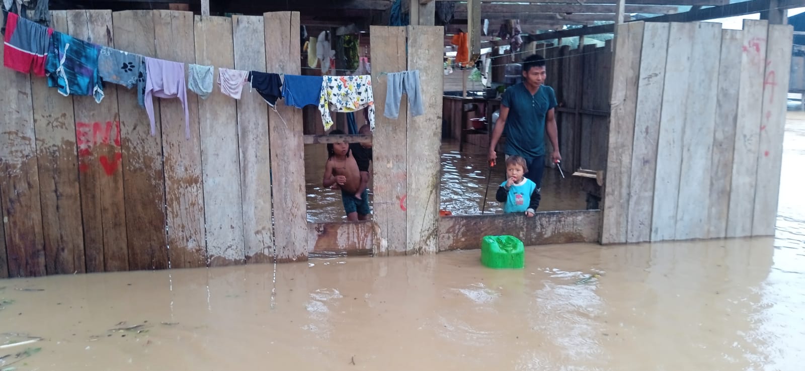 Una familia en una casa de madera en el medio de la inundación.
