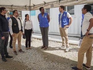 Representantes de las entidades que participaron en la misión están reunidos hablando, de pie, fuera de las instalaciones del centro de atención.