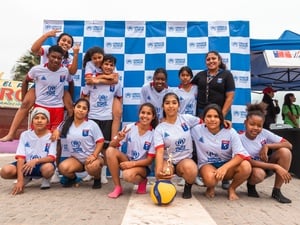 Un grupo de niñas y niños posa como lo haría un equipo de fútbol; detrás suyo, una lona con el logotipo de ACNUR