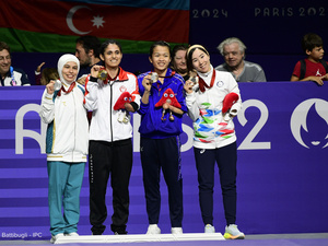 Cuatro mujeres posan juntas con medallas colgadas al cuello.