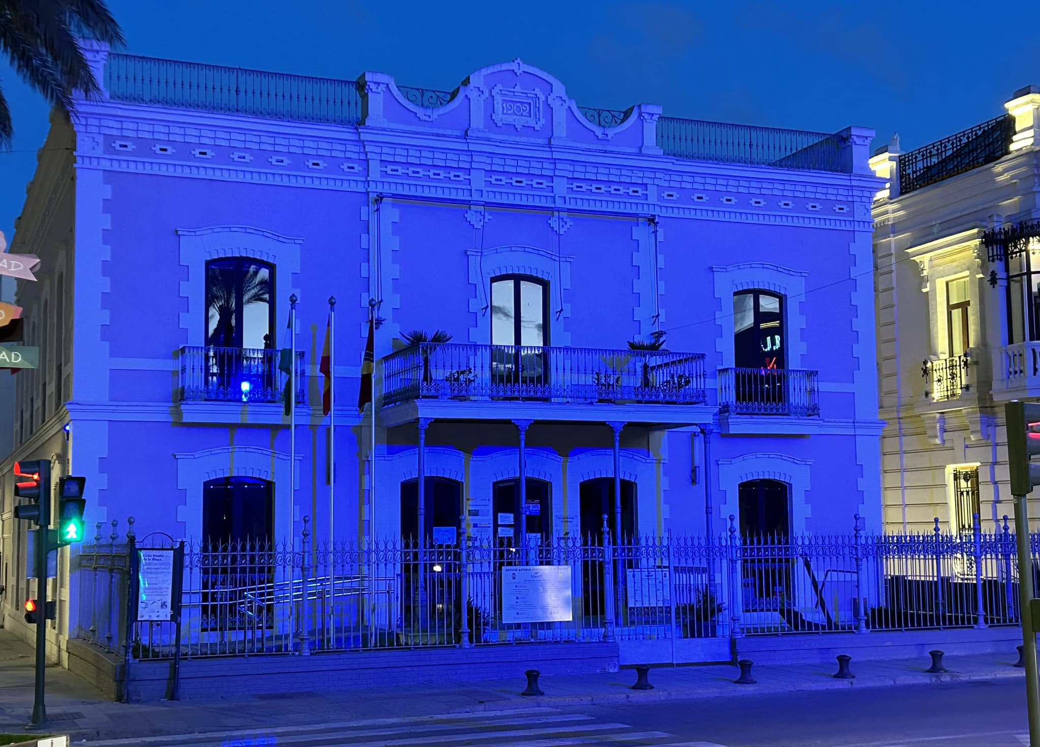 El edificio de la empresa municipal Eressan, en Sanlúcar de Barrameda, iluminado de azul en la víspera del Día Mundial del Refugiado.