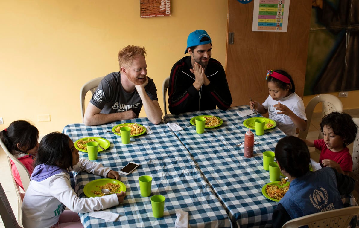 Colombia. UNHCR supporter Jesse Tyler Ferguson (centre) and his husband Justin Mikita (centre-right) spend time with Venezuelan refugee and migrant children