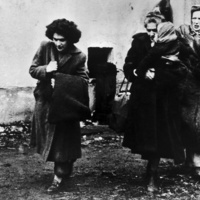 Fotografía en blanco y negro de tres mujeres con un niño que llegan a un campamento de refugiados en Austria