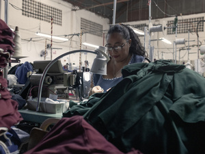 Una mujer trabaja en una fábrica con una máquina de coser.