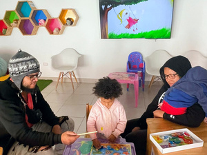 Dos adultos y dos niños en una sala de juegos