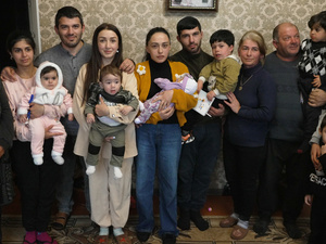 Una familia posa para una foto de grupo en la sala de su casa.