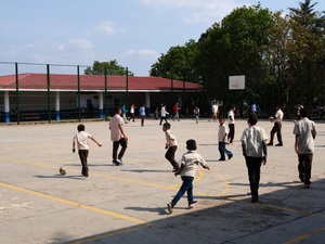 Niños practican deporte en una cancha escolar