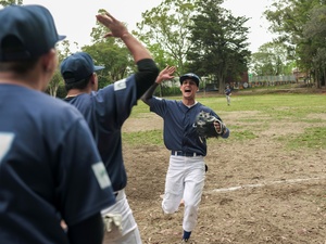 Jugadores de softball celebrando en la cancha durante un partido.