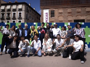 Participants in the UNHCR event in Madrid on the occasion of World Refugee Day pose in front of the Boa Mistura mural.