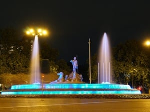 La fuente de Neptuno, en Madrid, iluminada de azul.